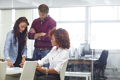 Buy stock photo Cropped shot of three colleagues discussing business in the office