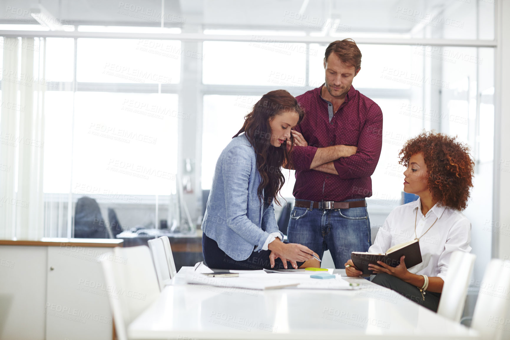 Buy stock photo Cropped shot of three colleagues discussing business in the office