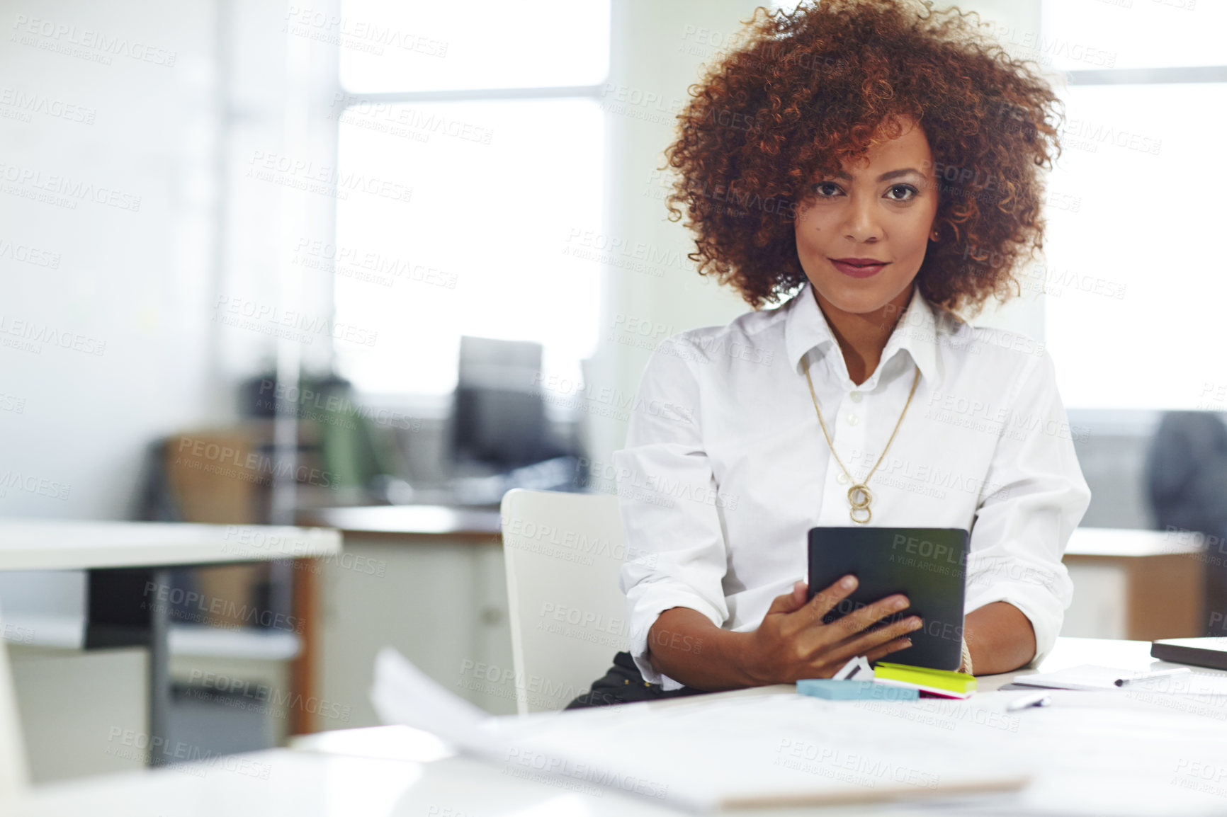 Buy stock photo Cropped shot of a beautiful young businesswoman using her tablet in the office