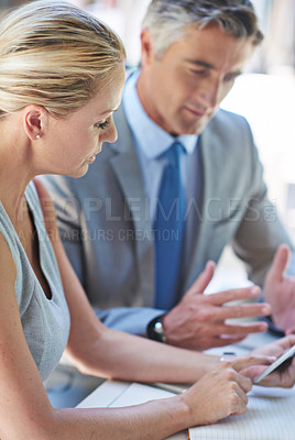 Buy stock photo Shot of two mature businesspeople talking together of a digital tablet