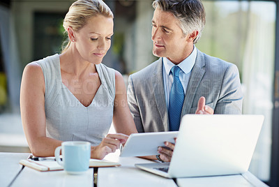 Buy stock photo Shot of two mature businesspeople talking together of a tablet and laptop