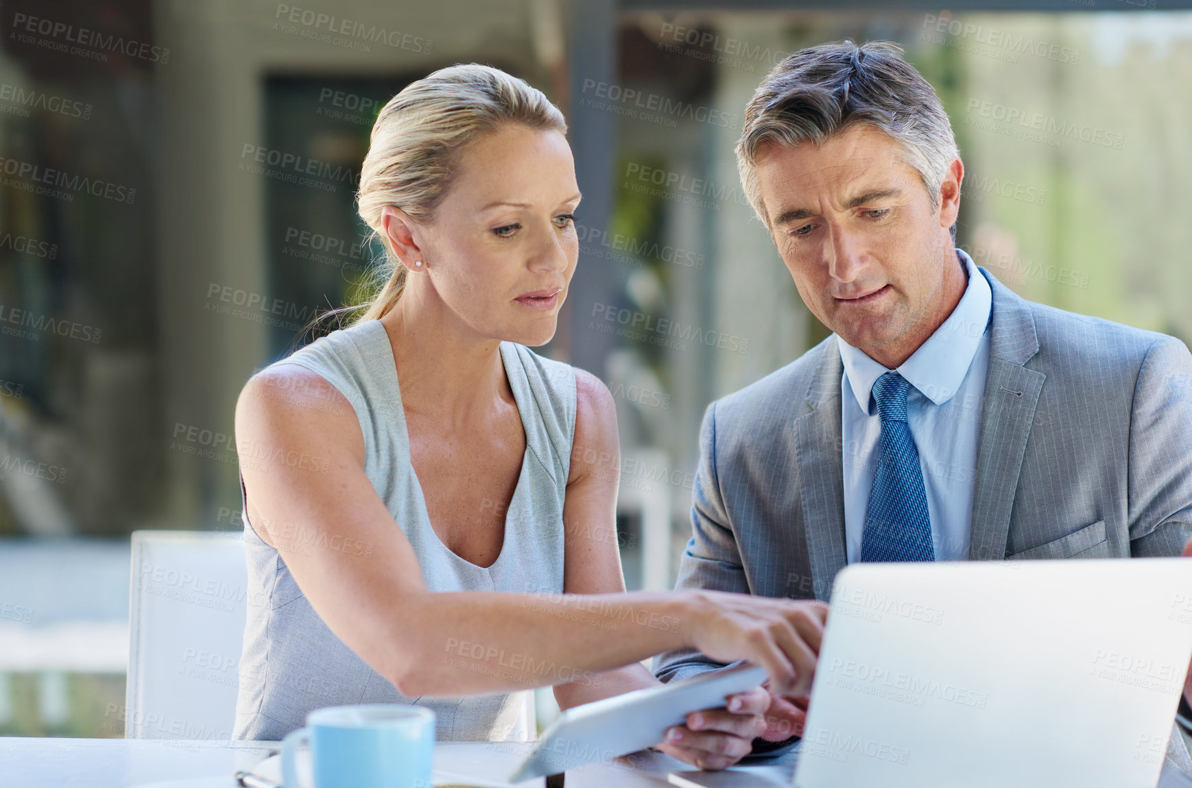Buy stock photo Shot of two mature businesspeople working on a laptop