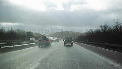 Buy stock photo Cars driving on a wet and rainy day. Staying safe and avoiding accidents on a highway. Asphalt road through the countryside on a cold and misty day, surrounded by trees and open grassland in Germany