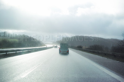 Buy stock photo Back, car and street with cloudy sky in countryside on cold or rainy weather with nature. Vehicle, scenery and wet highway for travel, road trip and adventure on holiday with journey or vacation