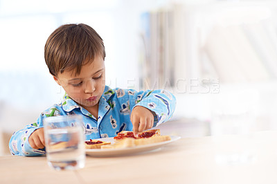 Buy stock photo Young, male kid and eating breakfast at table for healthy, sandwich and hungry in house. Morning, food and water for meal at home with bread, glass and boy inside for snack, nutrition and vitality