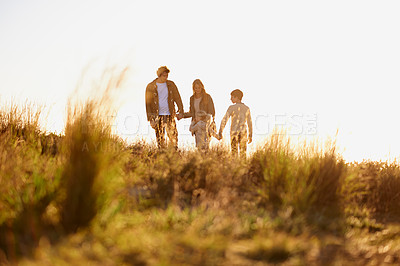 Buy stock photo Family, grass and walk at sunset, nature and bonding with exercise for parents and children. Lens flare, autumn and  hike on holiday in English countryside, mother and father for outdoor activity  