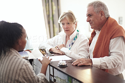 Buy stock photo Reception, hotel and senior couple on vacation or elderly person at concierge, desk or check in with lobby receptionist or secretary. Black woman, working in hospitality and help people in retirement