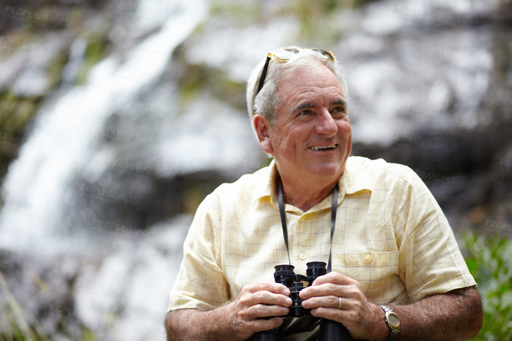 Buy stock photo Binoculars, happy man and forest or mountains thinking of journey, outdoor adventure and carbon footprint tourism. Senior person with gear for birdwatching experience or search nature by waterfall
