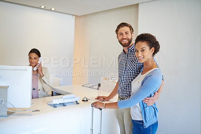 Buy stock photo Cropped shot of a young couple checking in to a hotel