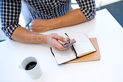 Buy stock photo Cropped shot of a businessman using his cellphone while working at his office desk