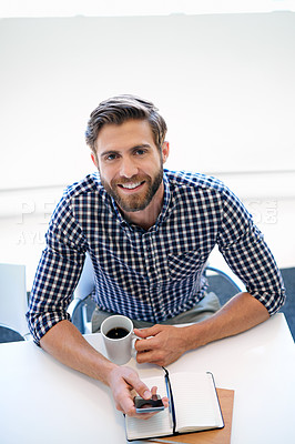 Buy stock photo Portrait of a businessman using his cellphone and drinking coffee at his office desk