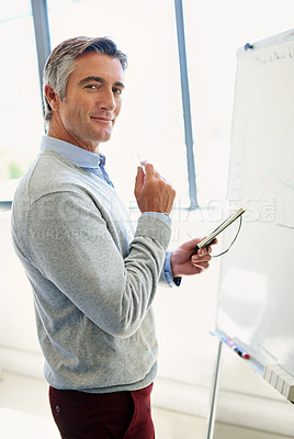 Buy stock photo Portrait of a mature business standing at a whiteboard holding a notebook