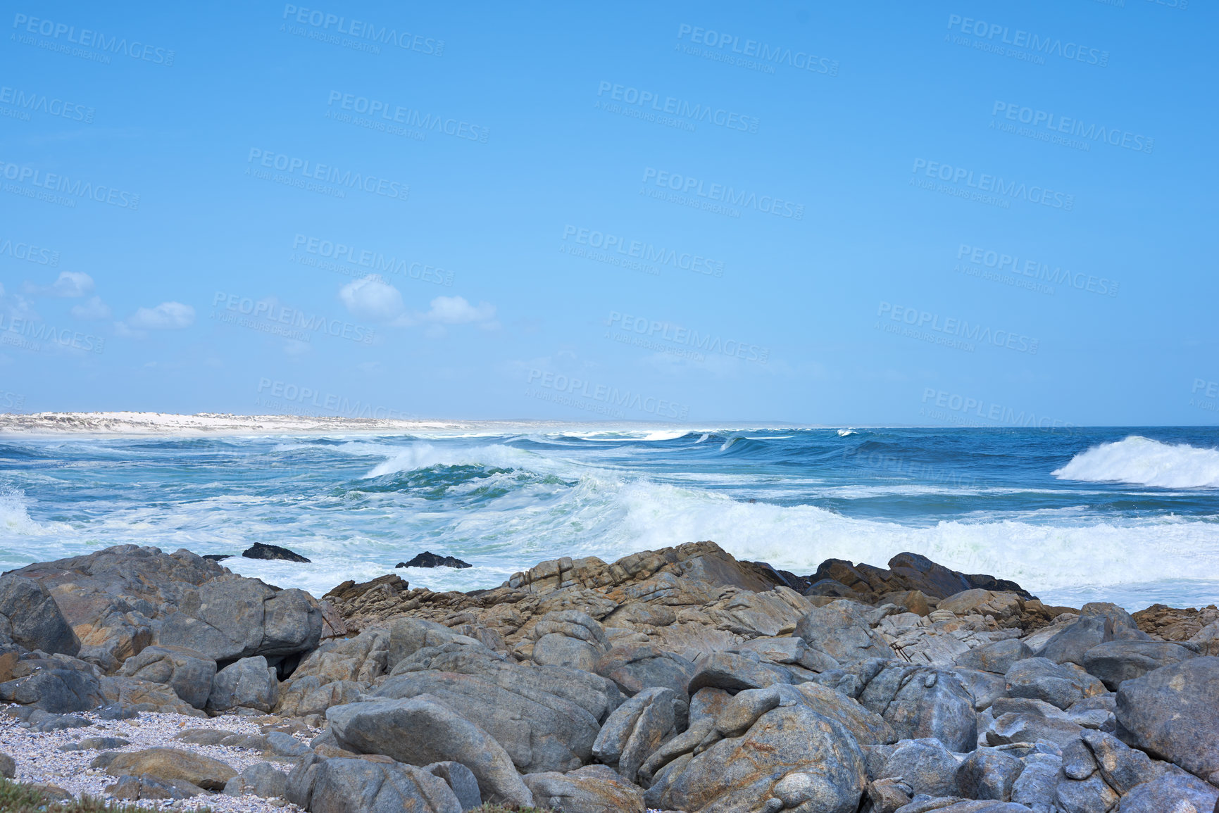 Buy stock photo Rocks in the ocean under a blue sky with copy space. Beautiful landscape of beach waves splashing against boulders or big stones in the sea at a popular summer location in Cape Town, South Africa