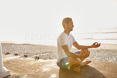 Buy stock photo Shot of a man meditating at the beach