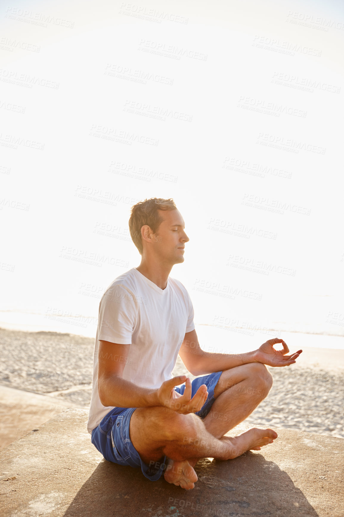 Buy stock photo Shot of a man meditating in the outdoors in the sun