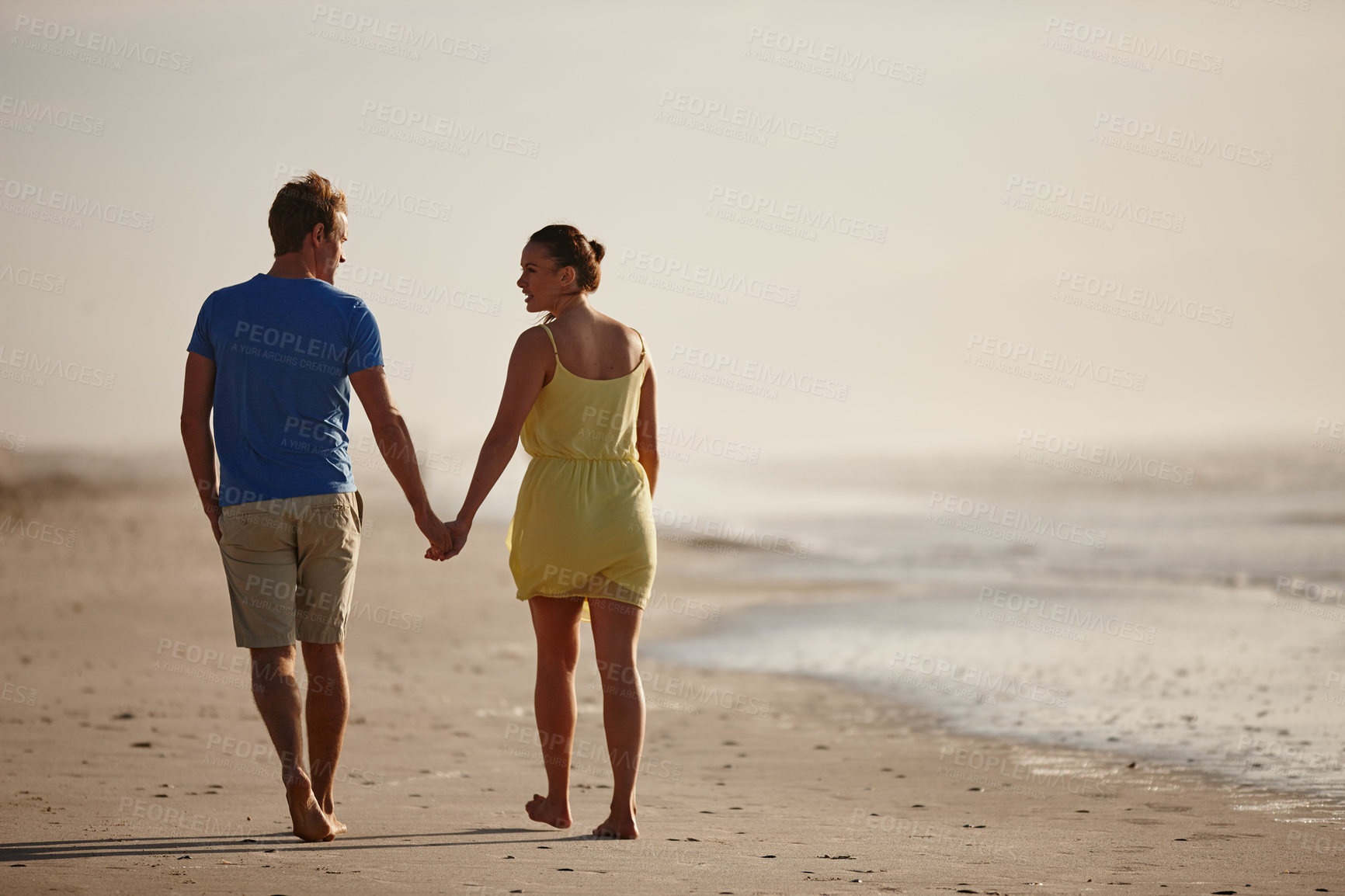 Buy stock photo Shot of an affectionate couple walking on the beach