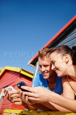 Buy stock photo Cropped shot of a couple looking at photos while on holiday