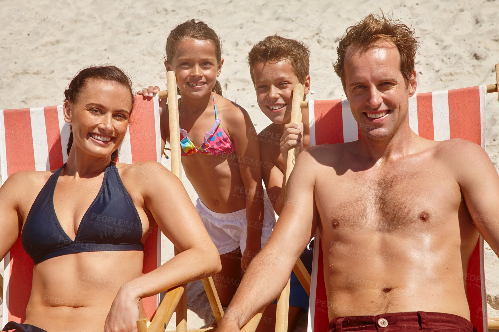Buy stock photo Portrait of a happy family enjoying a day at the beach