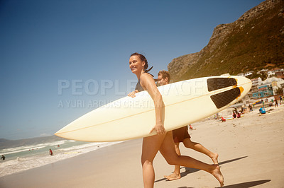 Buy stock photo Shot of a couple surfing together at their favourite beach