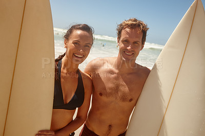 Buy stock photo Shot of a couple standing with their surfboards on the beach