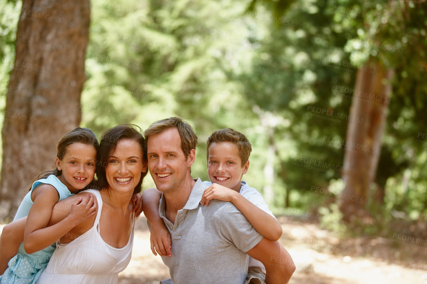 Buy stock photo Shot of a happy family spending quality time together in the forest