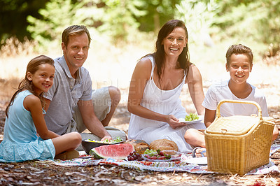 Buy stock photo Shot of a happy family having a picnic in the forest