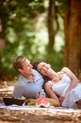 Buy stock photo Shot of an affectionate couple enjoying a picnic in the forest