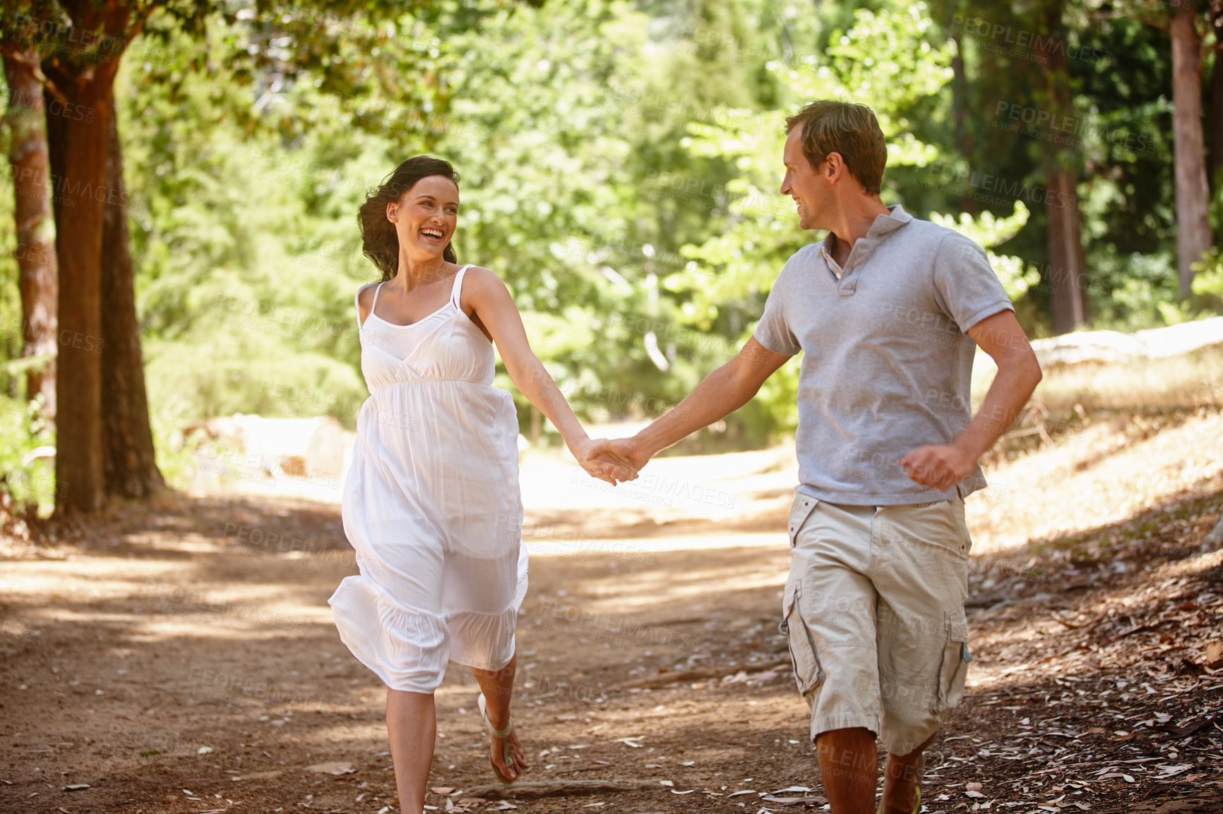 Buy stock photo Shot of a happy couple enjoying a carefree day together in the forest