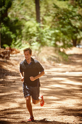 Buy stock photo Full length shot of a man jogging in a forrest