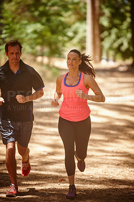 Buy stock photo Full length shot of a couple jogging in the forest