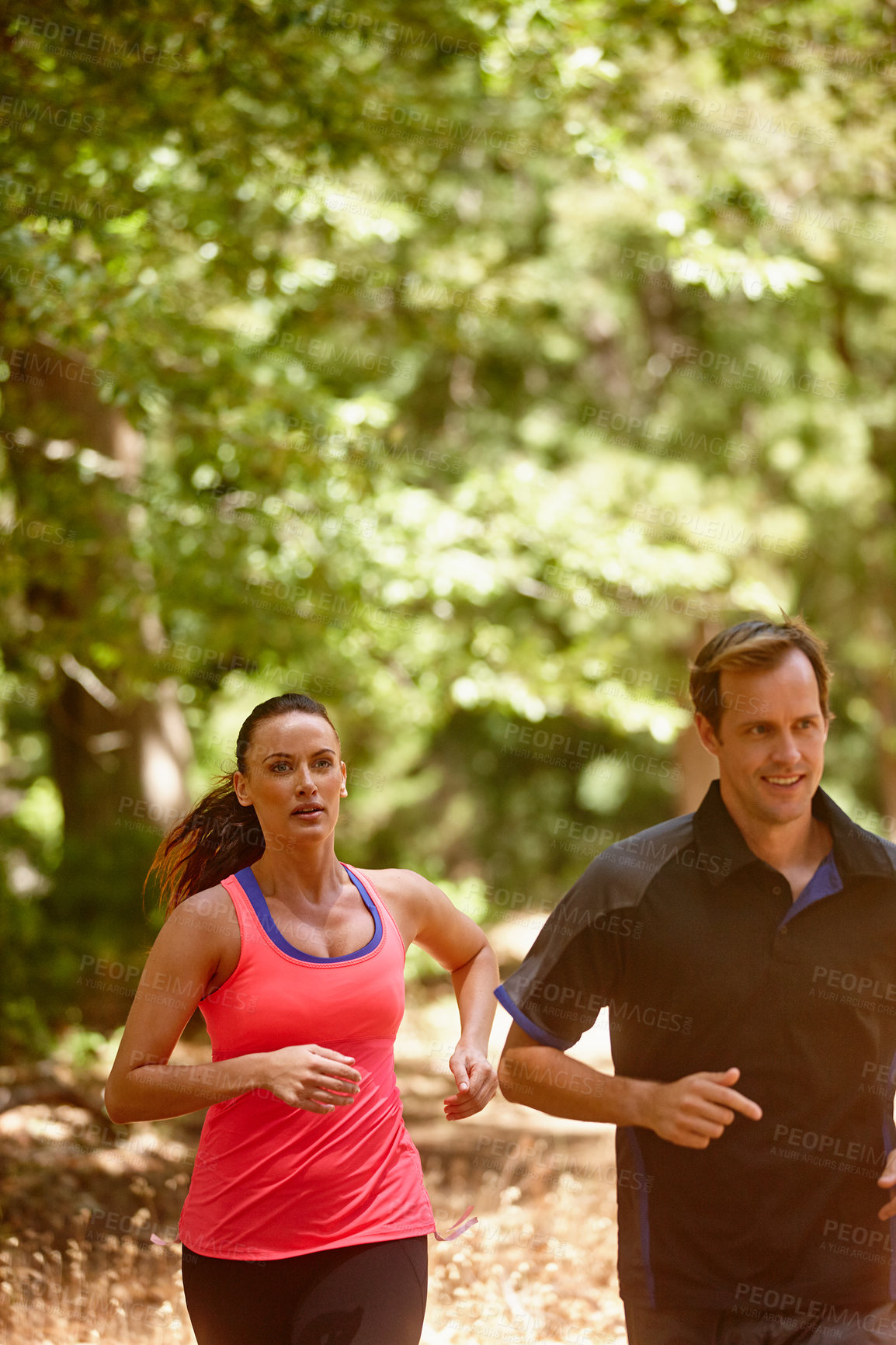 Buy stock photo Cropped shot of a couple jogging in the forest