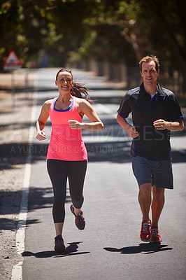 Buy stock photo Full length shot of a couple jogging on a road