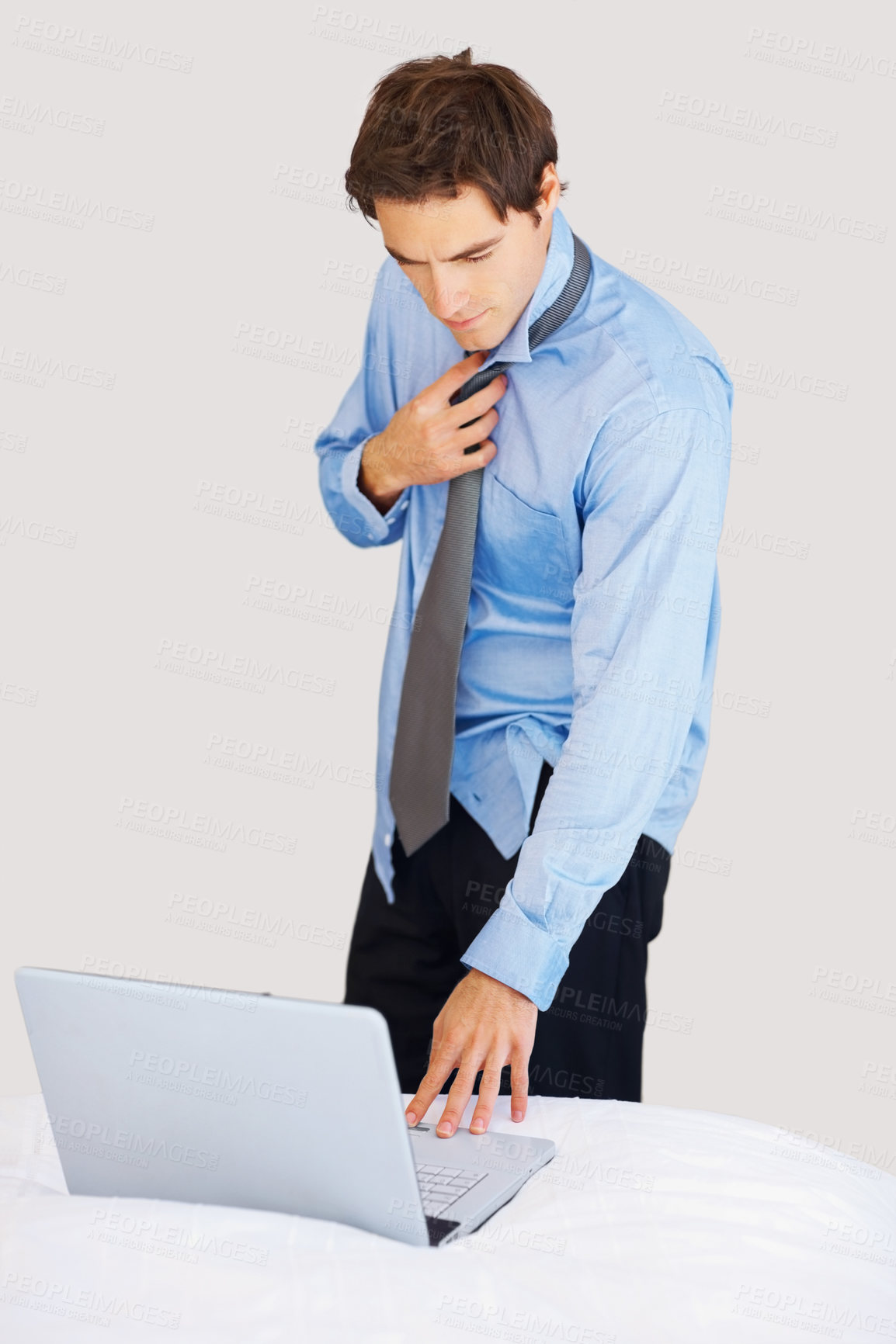 Buy stock photo Businessman, laptop and getting ready on bed for deadline, tasks or morning schedule plan at home. Man or employee working on computer while dressing tie or suit for formal business in the bedroom