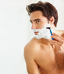 Smart young guy using a razor to shave