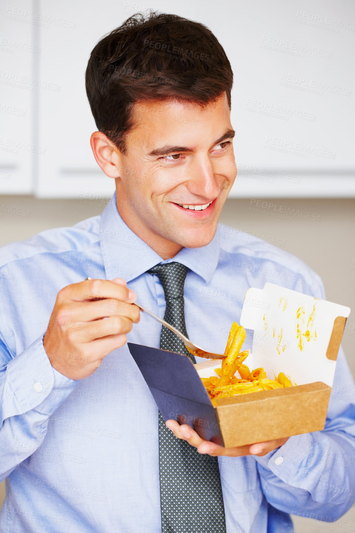 Buy stock photo Smile, fries and young businessman eating at his home for dinner, supper or lunch snack. Happy, professional and male person from Canada enjoying chips for meal in the kitchen at his modern apartment