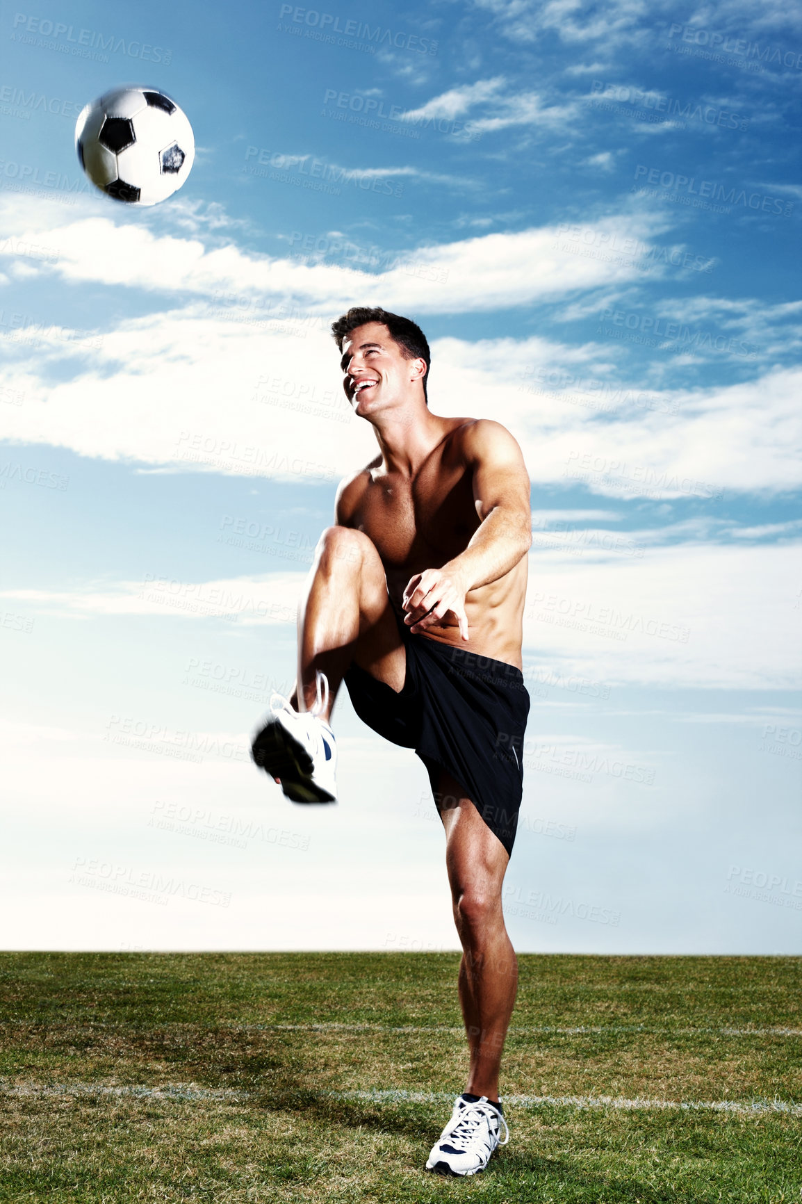 Buy stock photo Man, soccer player and ball kick on grass field or sports match or practice training, workout or professional. Male person, football and strong athlete with blue sky or fitness health, muscle or legs