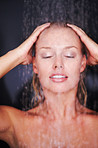 Woman under the shower against dark background