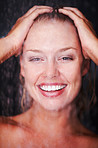 Closeup of a woman enjoying a shower against a dark background