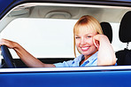 Pretty woman smiling from the driver's seat of a car