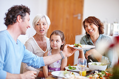 Buy stock photo Shot of a multi-generational family having a meal together