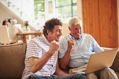 Buy stock photo Shot of a man and his father looking excited while watching something on a laptop