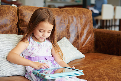 Buy stock photo Shot of a little girl using a digital tablet at home