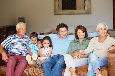 Buy stock photo Shot of a happy multi-generational family sitting together on a sofa