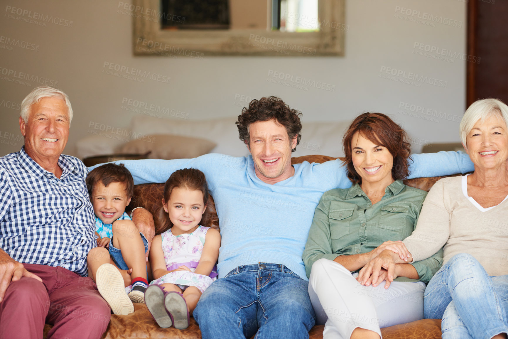 Buy stock photo Shot of a happy multi-generational family sitting together on a sofa