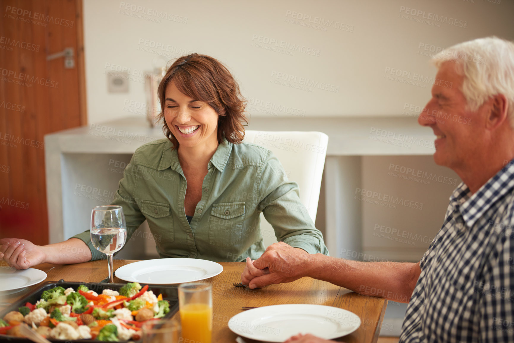 Buy stock photo Shot of a family praying together before having a meal