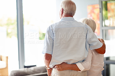 Buy stock photo Rearview shot of a senior couple looking through their living room window