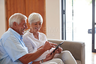 Buy stock photo Shot of a senior couple using a digital tablet at home