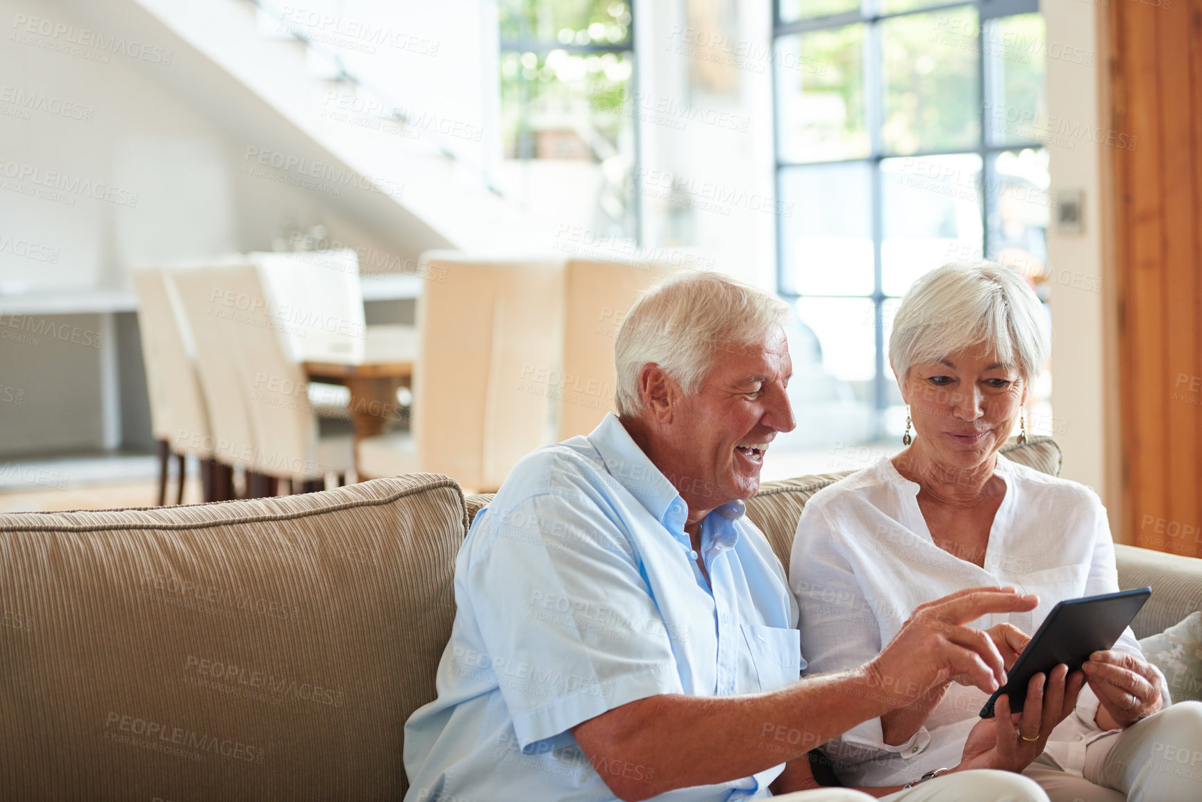 Buy stock photo Shot of a senior couple using a digital tablet at home