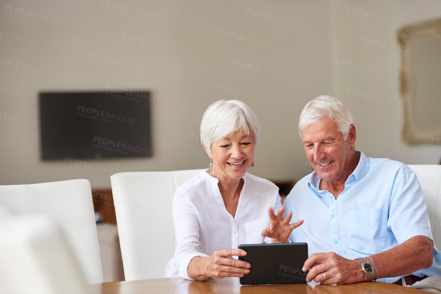 Buy stock photo Shot of a senior couple using a digital tablet at home