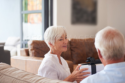 Buy stock photo Shot of a senior man giving his wife a gift